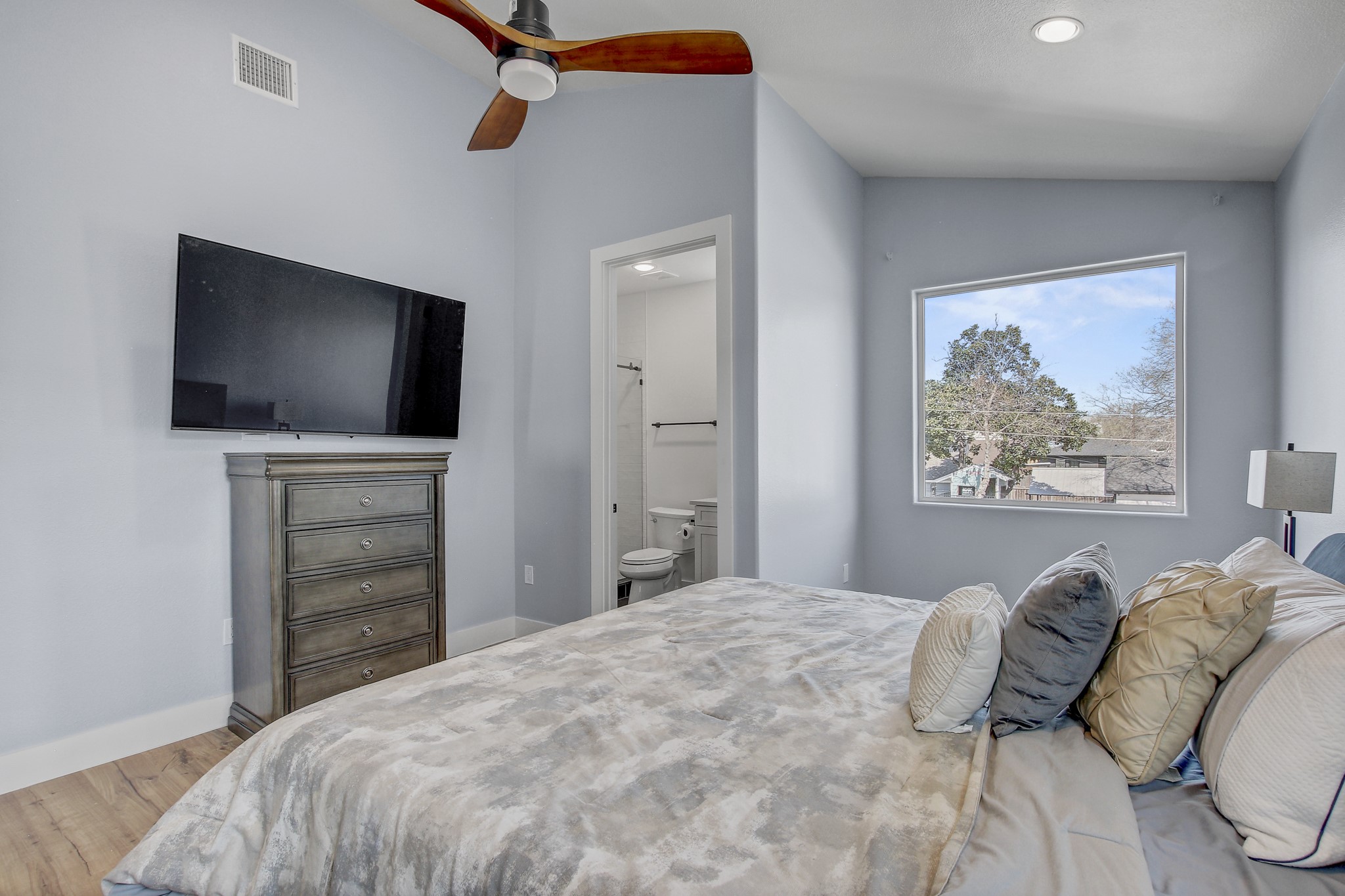 4703 Louis Avenue, Unit A Austin, TX 78721 - Photo 26 of 35 Bedroom featuring vaulted ceiling, light wood-style floors, a ceiling fan, ensuite bathroom, and recessed lighting