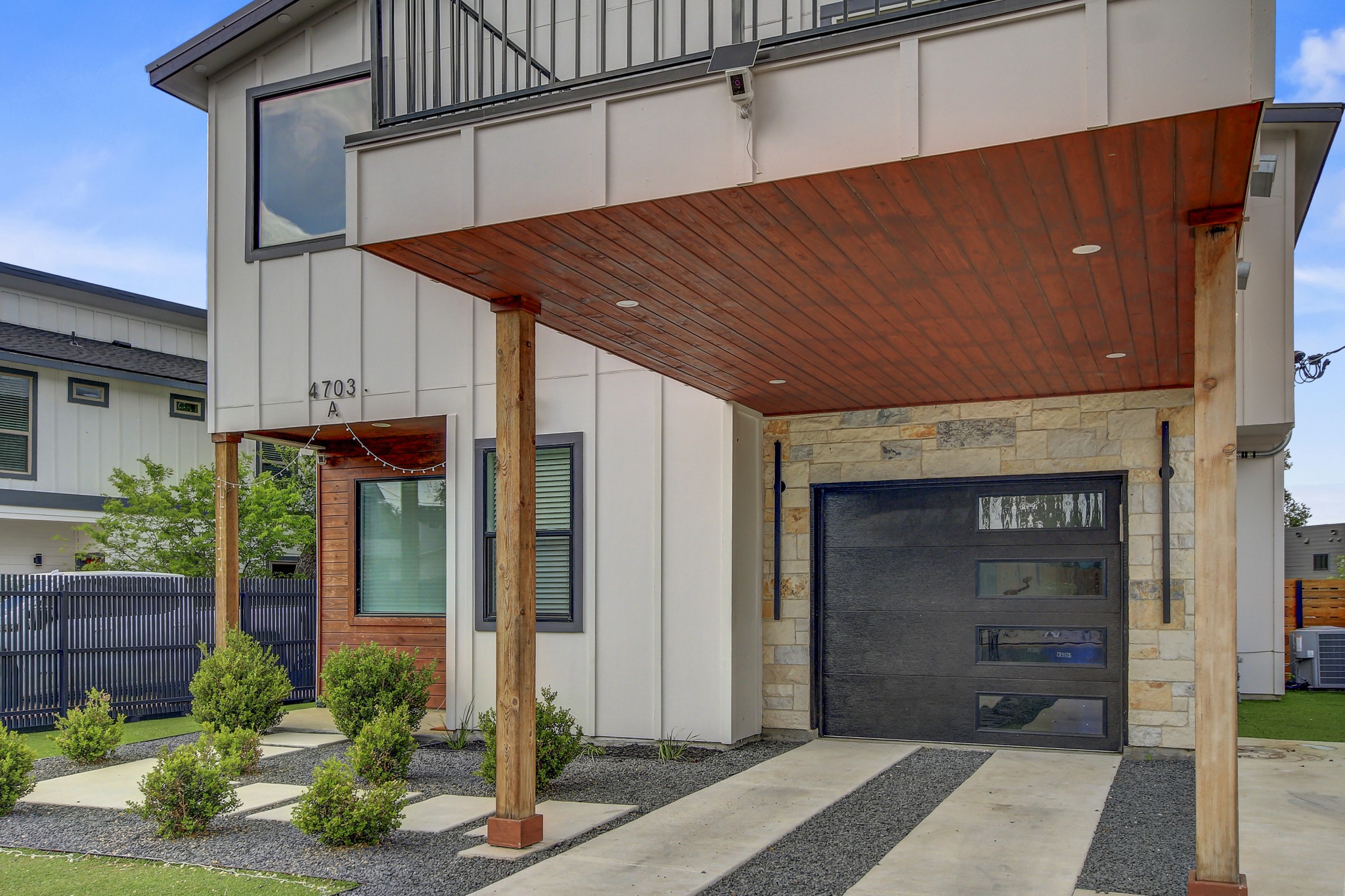 4703 Louis Avenue, Unit A Austin, TX 78721 - Photo 3 of 35 Entrance to property with board and batten siding, stone siding, and a garage