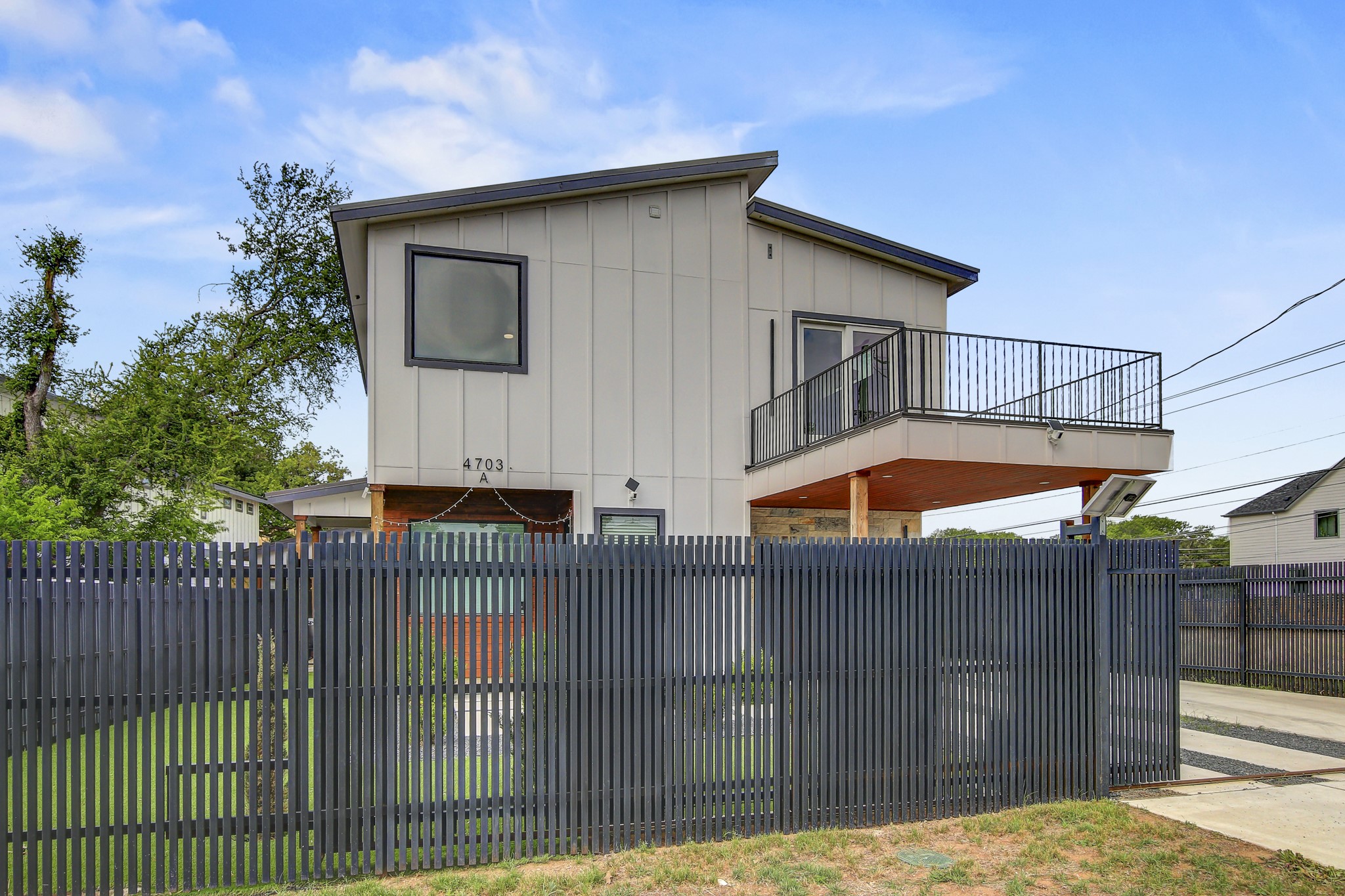 4703 Louis Avenue, Unit A Austin, TX 78721 - Photo 32 of 35 View of home's exterior featuring board and batten siding and a balcony