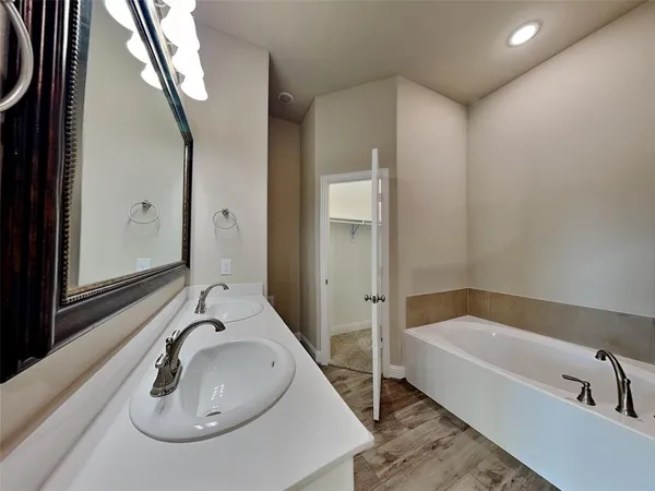 a bathroom with a tub sink and mirror