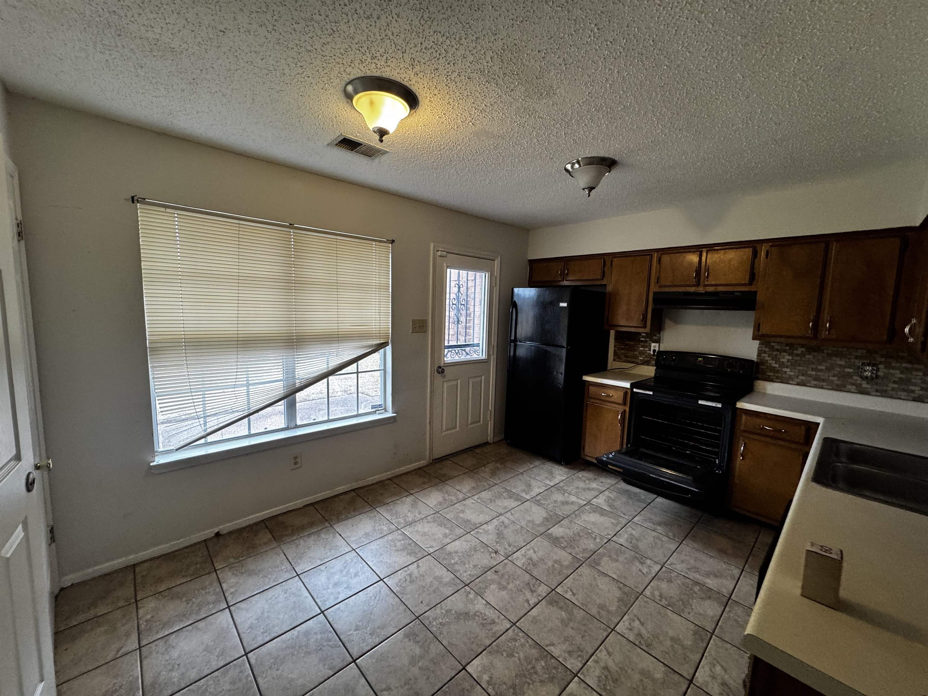 5840 Hickory Shadow Lane Memphis, TN 38141 - Photo 2 of 11 a kitchen with granite countertop a refrigerator and a stove top oven