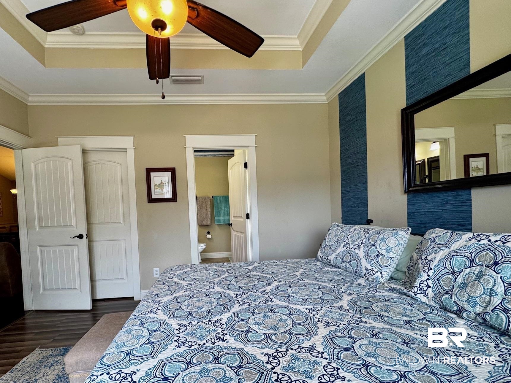 1030 Crown Walk Drive Foley, AL 36535 - Photo 15 of 40 Bedroom featuring connected bathroom, a tray ceiling, wood finished floors, and ornamental molding