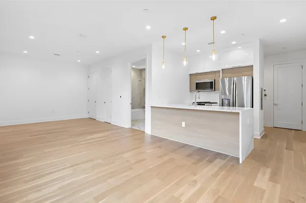 a large kitchen with kitchen island a sink stainless steel appliances and cabinets