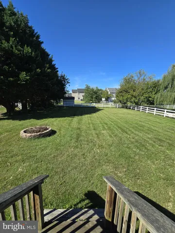 a view of a green field with wooden fence
