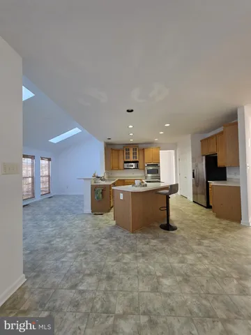 a large kitchen with a stove a sink a microwave and a refrigerator