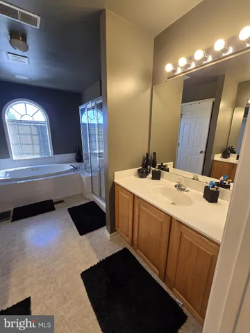 a bathroom with a double vanity sink a toilet a mirror and shower