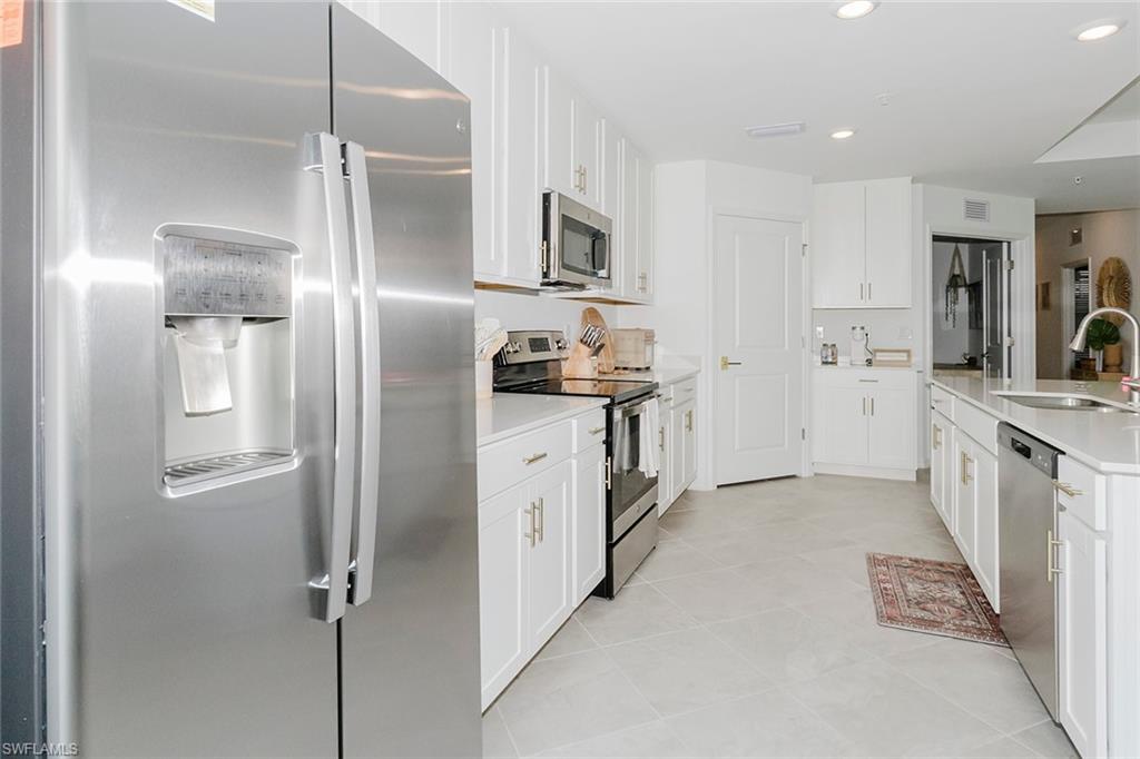 5445 Double Eagle Circle, Unit 3013 Ave Maria, FL 34142 - Photo 5 of 41 a kitchen with stainless steel appliances a refrigerator sink and stove
