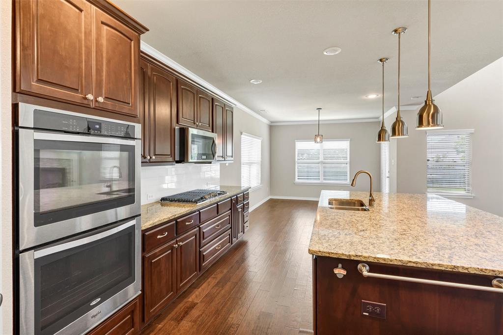 420 Prairie Run Aledo, TX 76008 - Photo 11 of 37 a kitchen with granite countertop stainless steel appliances and wooden cabinets