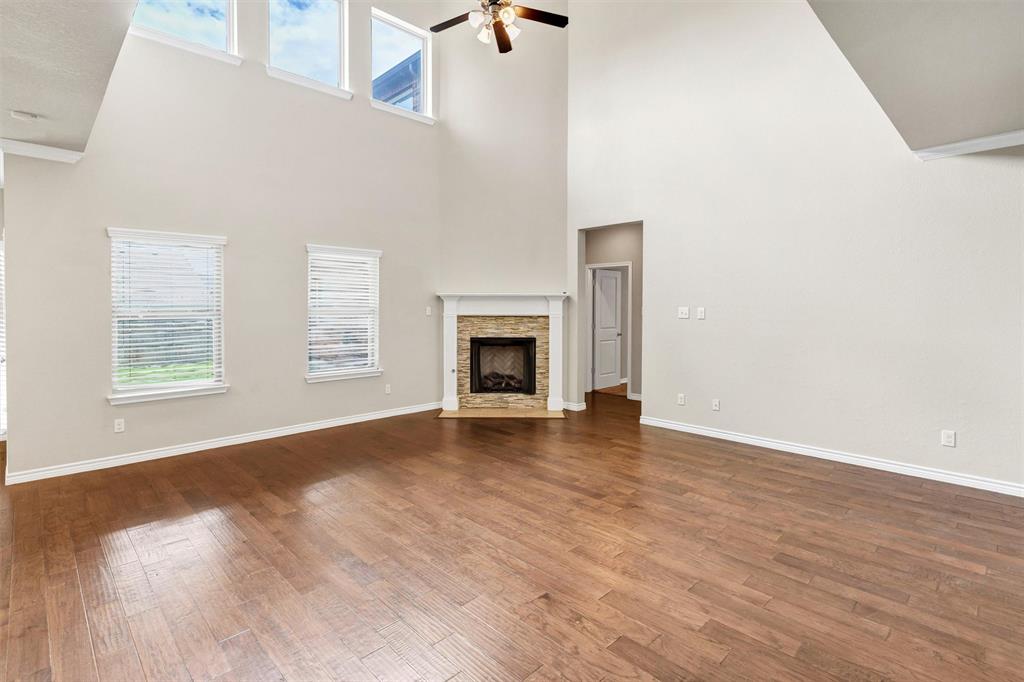420 Prairie Run Aledo, TX 76008 - Photo 14 of 37 an empty room with wooden floor fireplace and windows