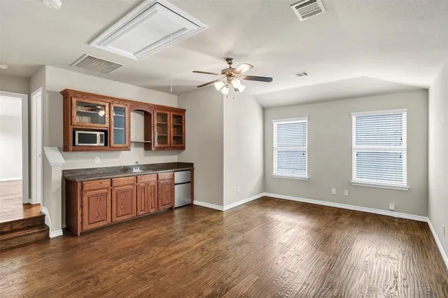 a kitchen with stainless steel appliances granite countertop a stove a sink dishwasher and a large window with wooden floor
