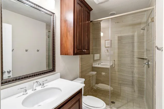 a bathroom with a sink toilet a mirror and shower