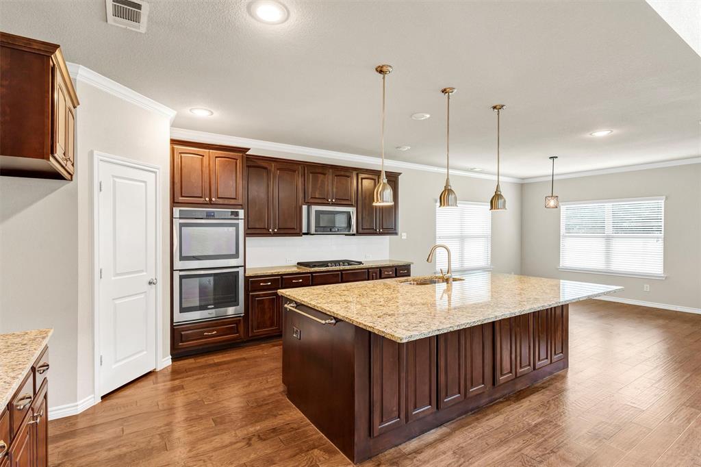 420 Prairie Run Aledo, TX 76008 - Photo 8 of 37 a kitchen with stainless steel appliances granite countertop a stove a refrigerator a sink and a microwave