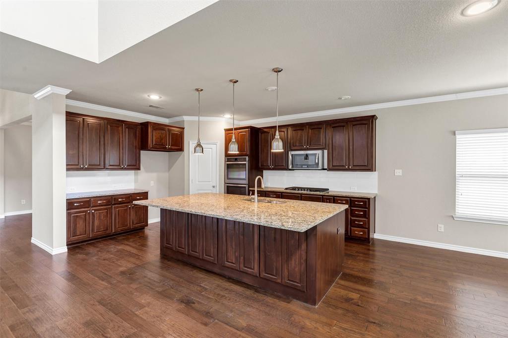 420 Prairie Run Aledo, TX 76008 - Photo 9 of 37 a large kitchen with stainless steel appliances granite countertop a large counter top and wooden floors