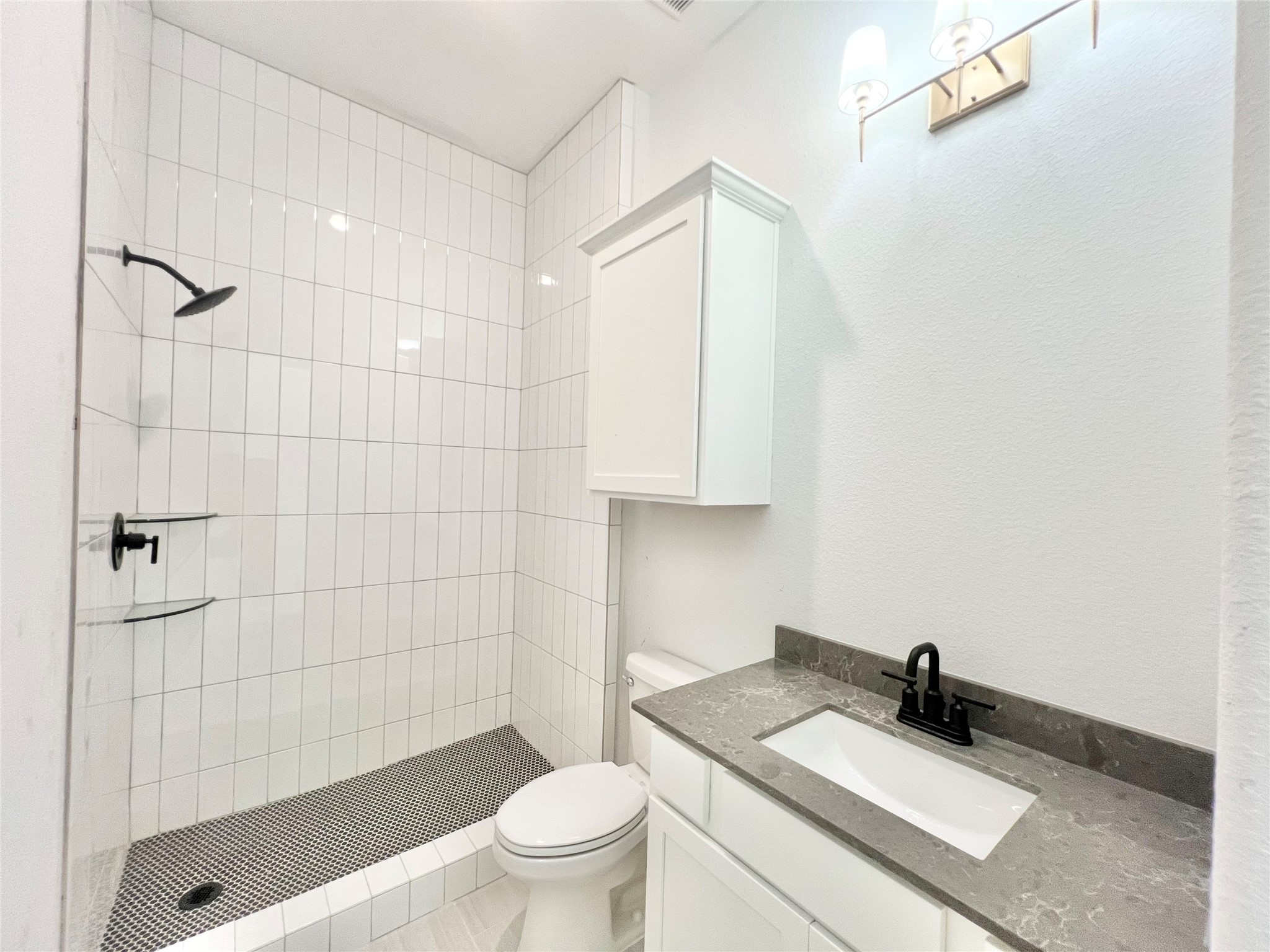 15722 North Tower Circle Santa Fe, TX 77517 - Photo 16 of 30 a bathroom with a granite countertop sink a toilet and shower