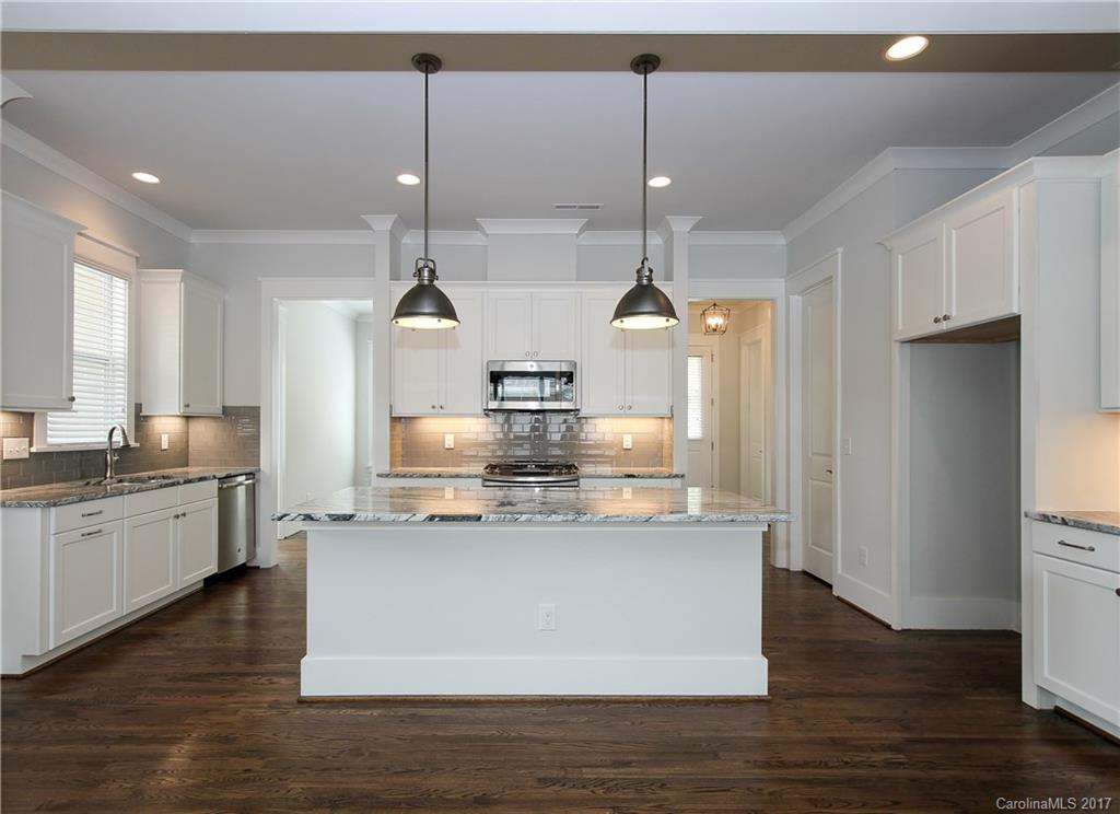 904 Millbrook Road, Unit 7A Charlotte, NC 28211 - Photo 3 of 22 a large kitchen with stainless steel appliances kitchen island a large counter top and wooden floor