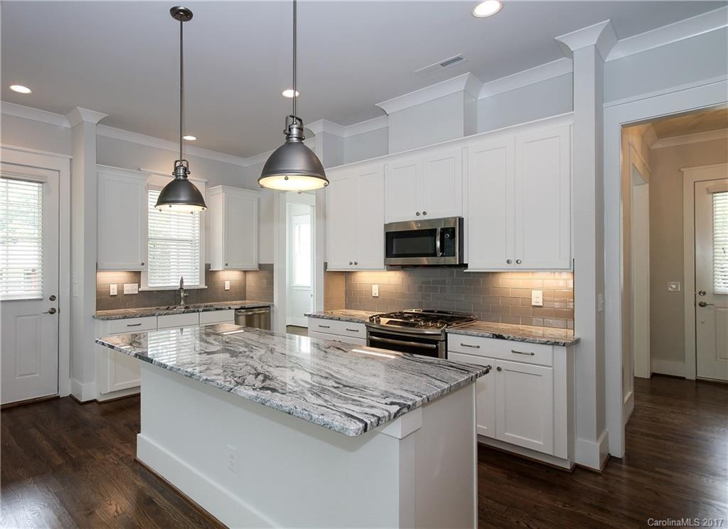 904 Millbrook Road, Unit 7A Charlotte, NC 28211 - Photo 4 of 22 a kitchen with stainless steel appliances granite countertop a stove a sink and a wooden floor