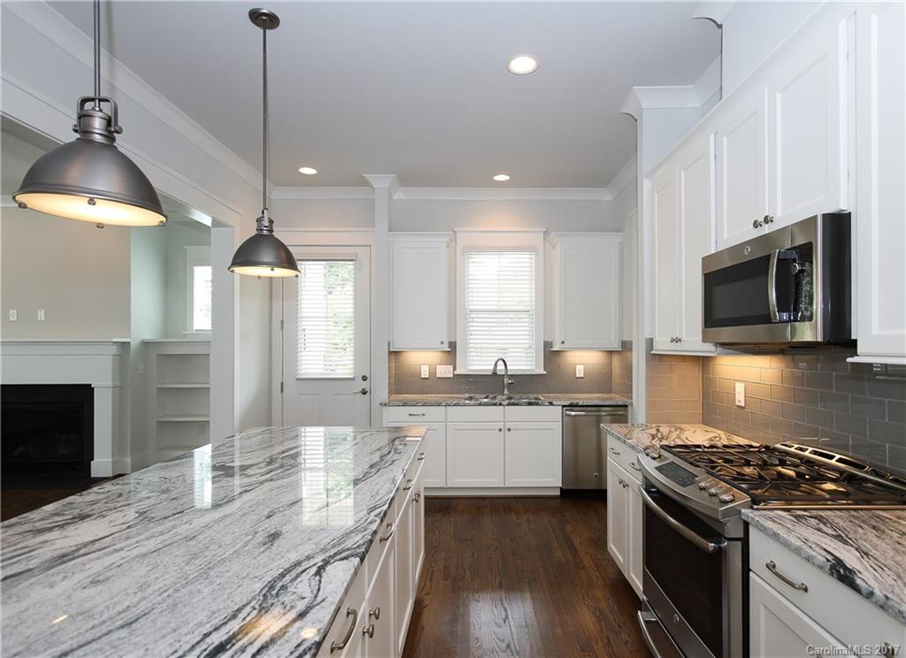904 Millbrook Road, Unit 7A Charlotte, NC 28211 - Photo 6 of 22 a large kitchen with granite countertop a stove top oven a sink a counter space and cabinets