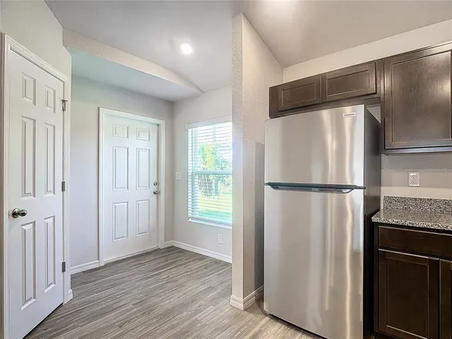a view of a kitchen with a refrigerator wooden floor and a kitchen