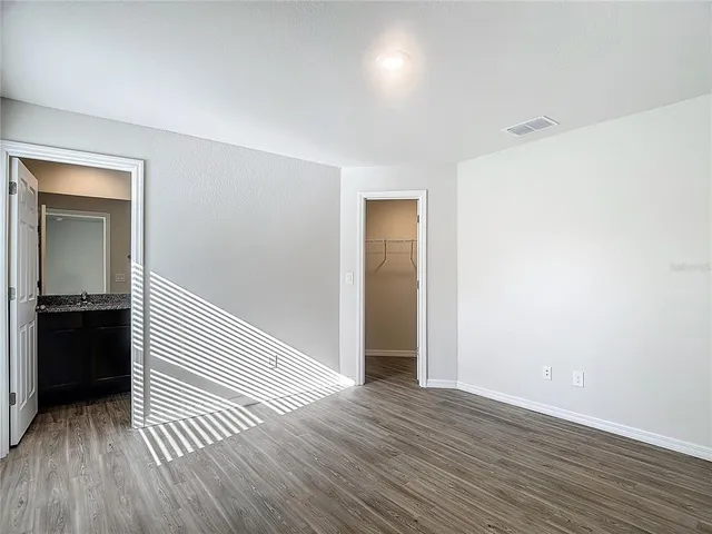 a view of a hallway with wooden floor and closet