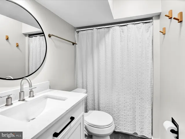 a bathroom with a sink vanity mirror and toilet