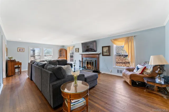 a living room with furniture a fireplace a flat screen tv and a large window