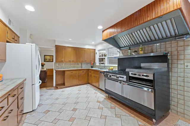 a kitchen with stainless steel appliances a stove sink and cabinets