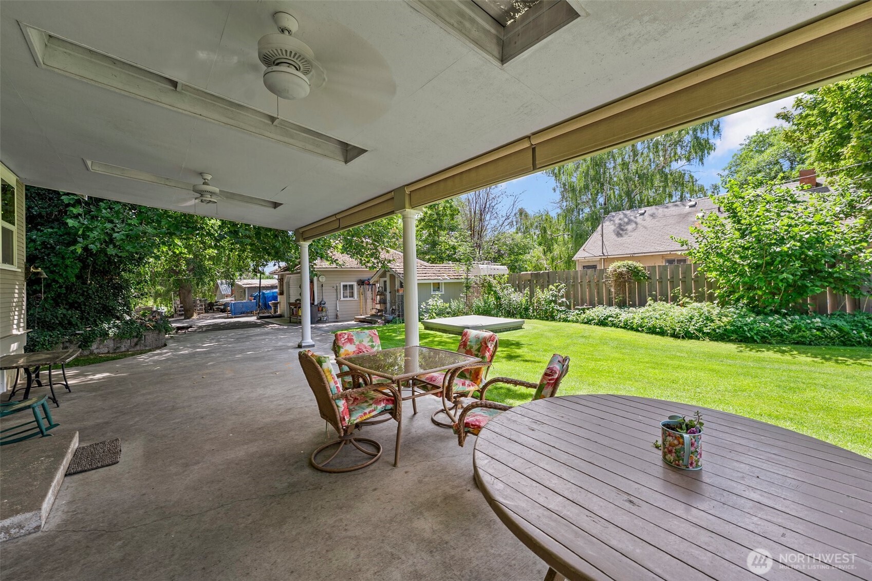 1121 Scoon Road Sunnyside, WA 98944 - Photo 33 of 39 a view of patio with table and chairs potted plants with wooden floor and fence
