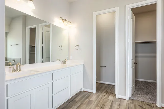 a bathroom with a double vanity sink and mirror