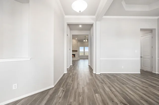 a view of a hallway with wooden floor and a bathroom