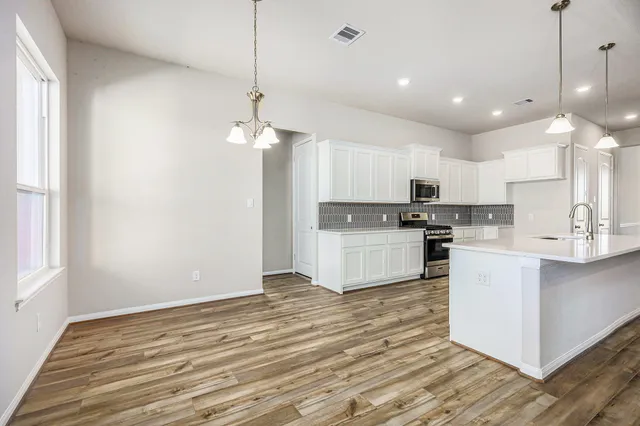 a kitchen with white cabinets and stainless steel appliances