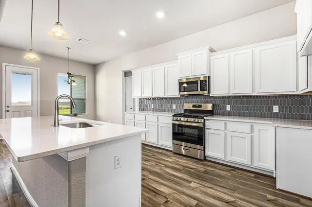 a kitchen with granite countertop a stove and a sink