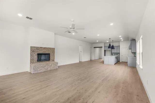 a view of an empty room with a fireplace and a window