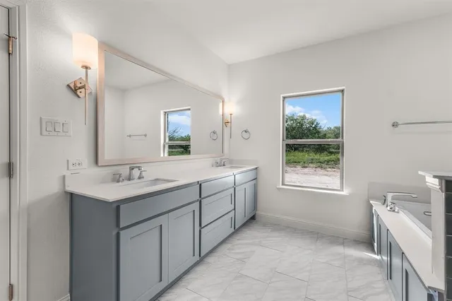 a spacious bathroom with a granite countertop sink a toilet and a mirror