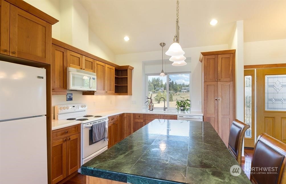 2493 Atterberry Road Sequim, WA 98382 - Photo 19 of 29 a large kitchen with stainless steel appliances granite countertop a refrigerator a sink dishwasher a stove and white countertops with wooden floor