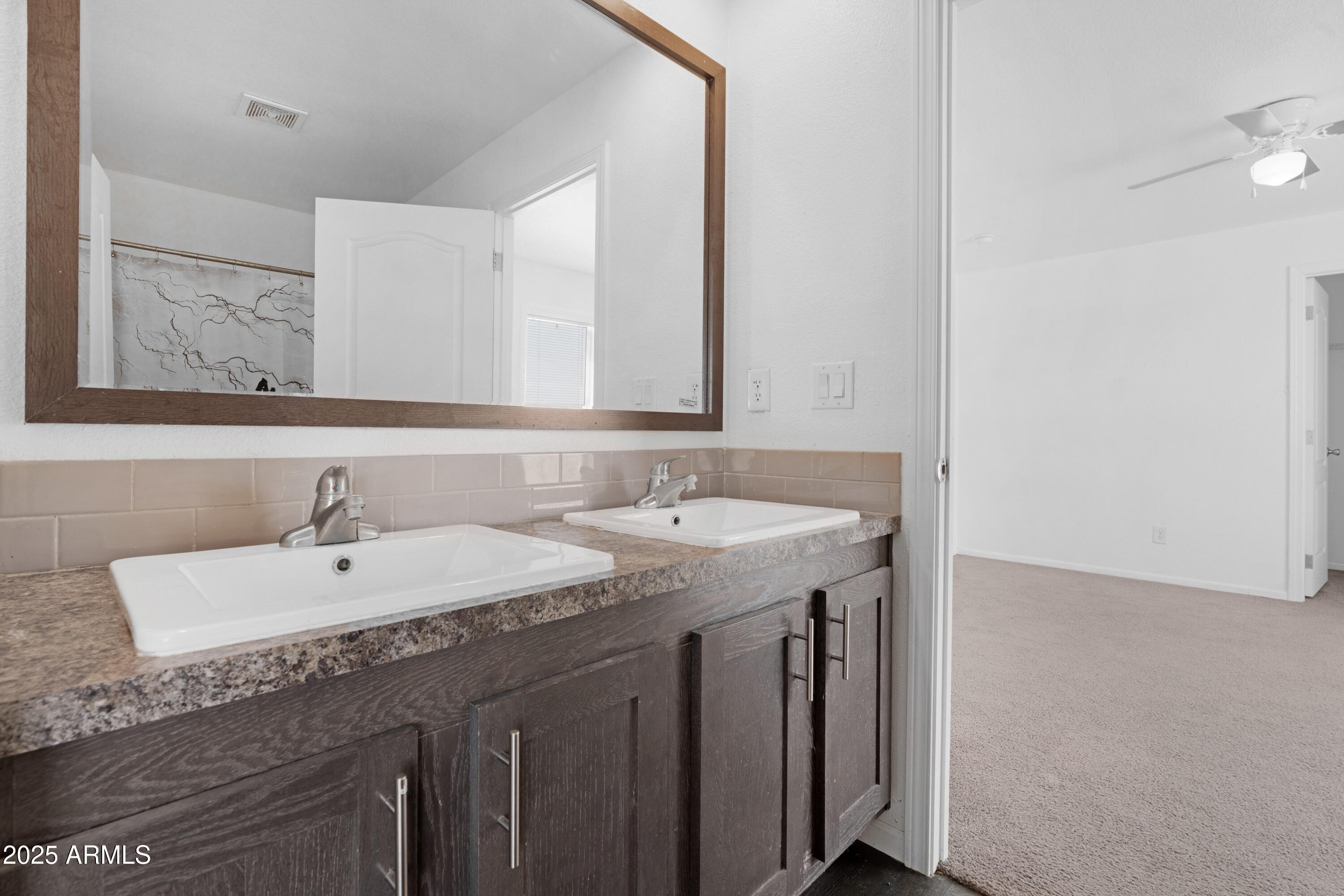 4318 North White Road Maricopa, AZ 85139 - Photo 12 of 21 a bathroom with a granite countertop sink and a mirror