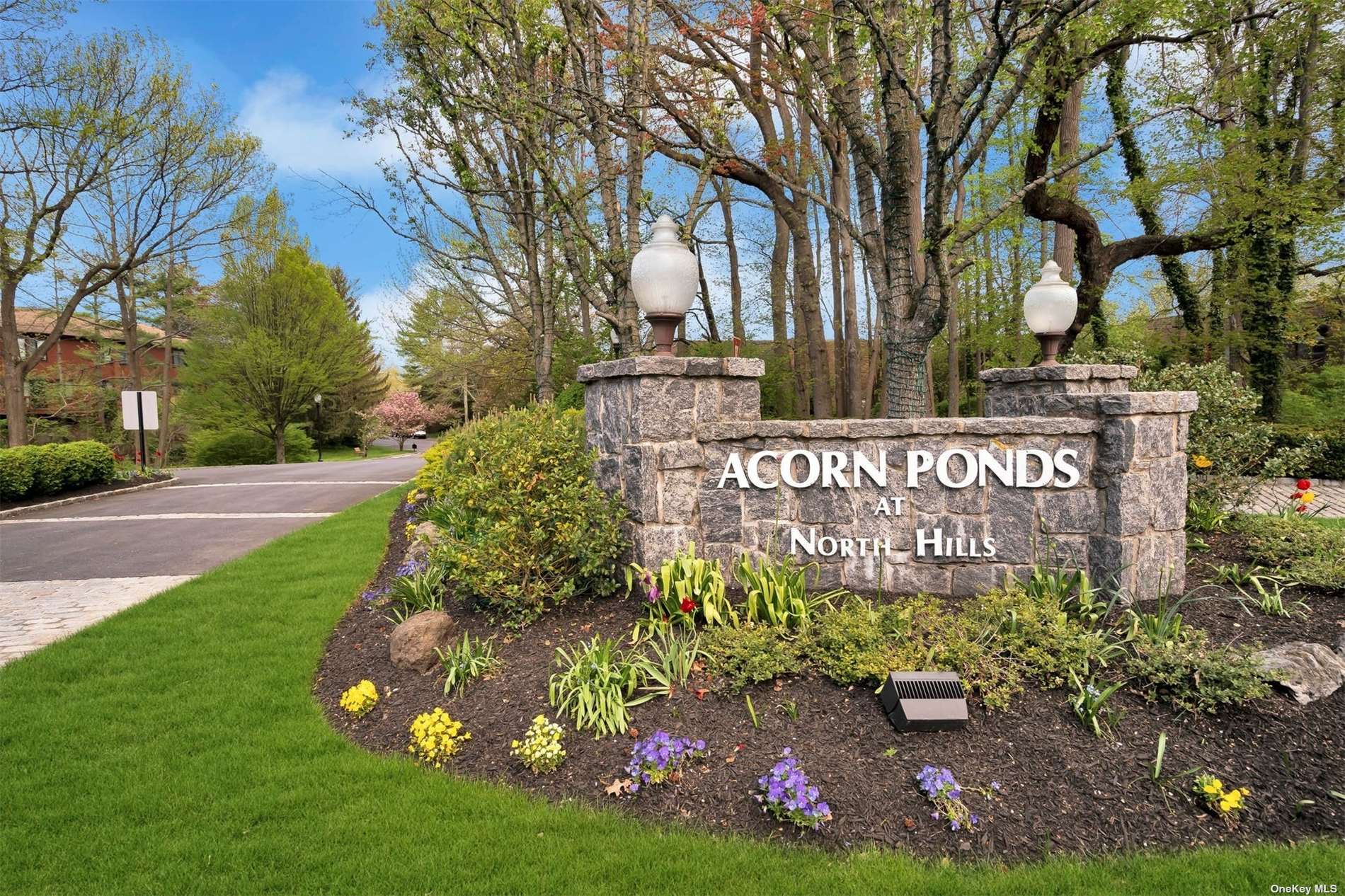 20 Spring Hollow Road, Unit 20 Roslyn, NY 11576 - Photo 1 of 1 a sign that is sitting in front of flowers