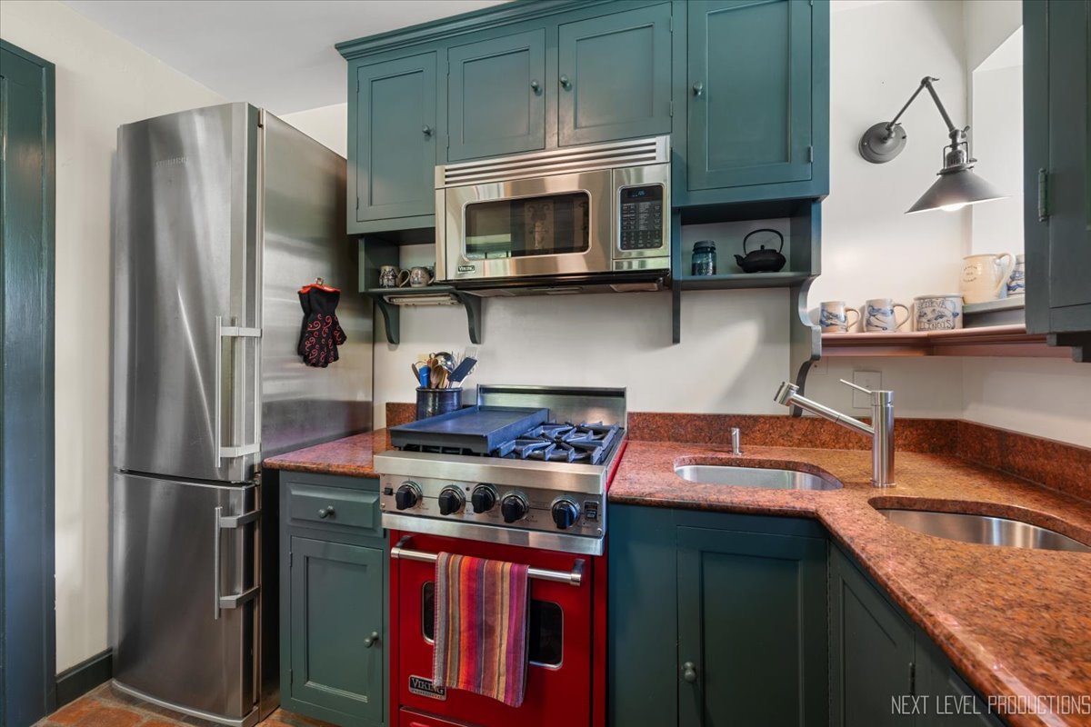 301 South 1st Street Geneva, IL 60134 - Photo 6 of 25 a kitchen with stainless steel appliances granite countertop a stove microwave refrigerator and sink