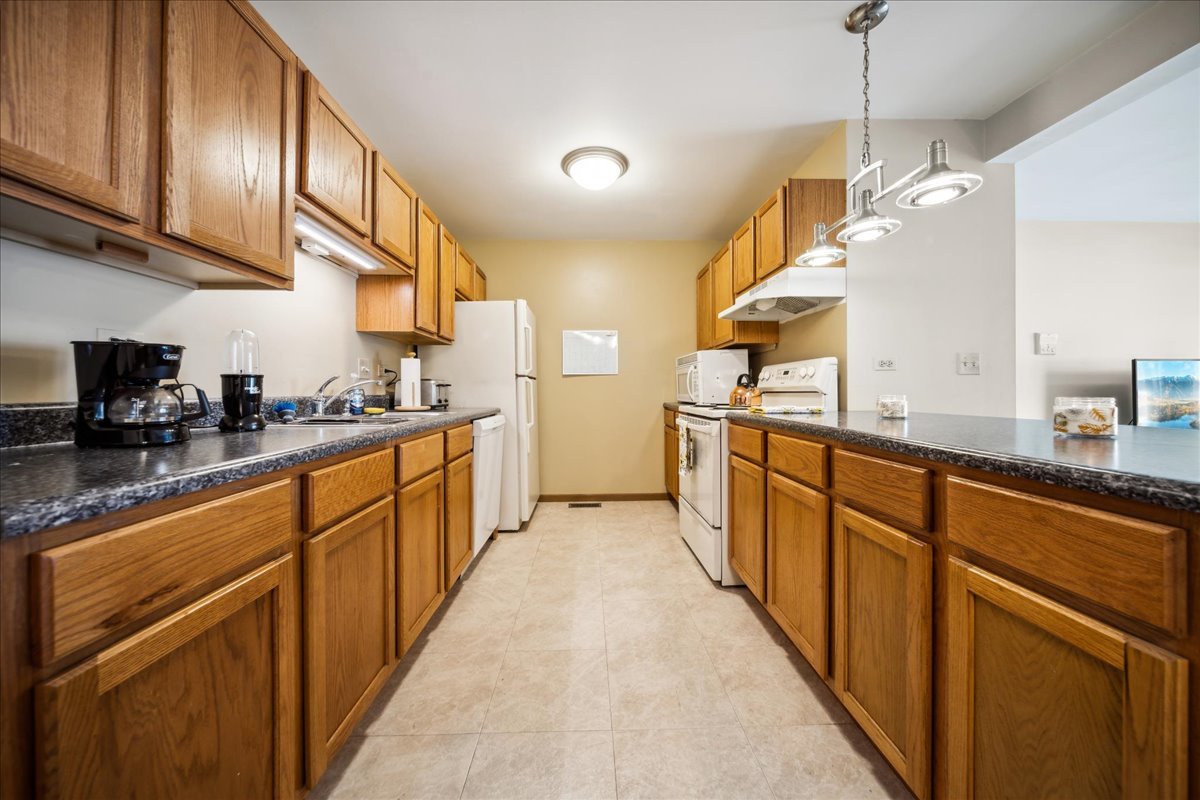 935 Golf Course Road, Unit 1 Crystal Lake, IL 60014 - Photo 5 of 10 a kitchen with stainless steel appliances granite countertop a sink a stove and a refrigerator