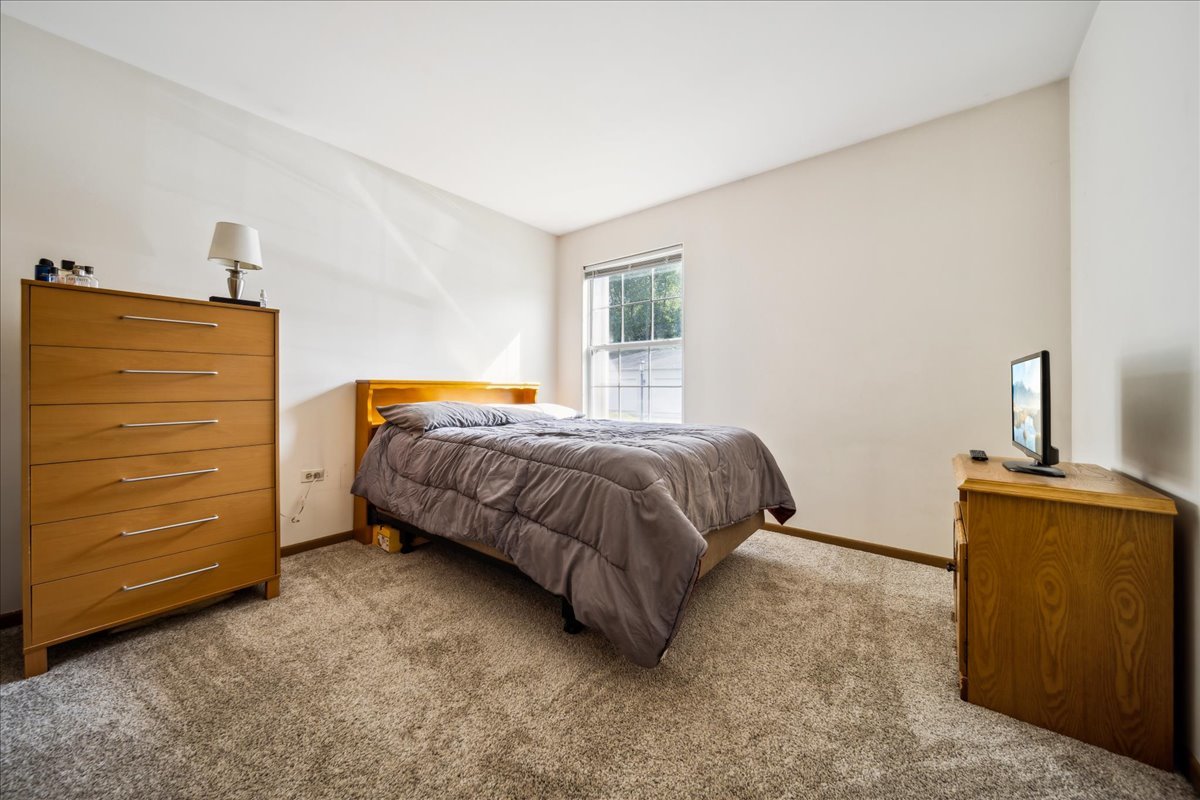 935 Golf Course Road, Unit 1 Crystal Lake, IL 60014 - Photo 6 of 10 a bedroom with a bed and furniture