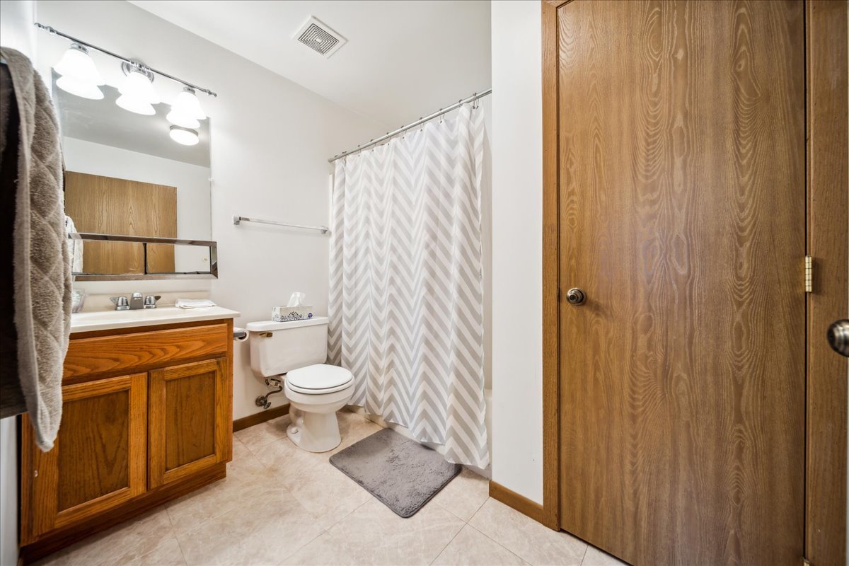 935 Golf Course Road, Unit 1 Crystal Lake, IL 60014 - Photo 8 of 10 a bathroom with a granite countertop sink toilet and shower