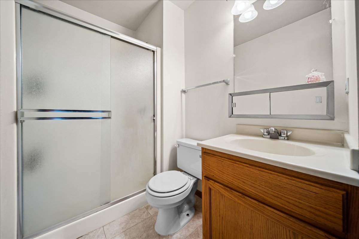 935 Golf Course Road, Unit 1 Crystal Lake, IL 60014 - Photo 9 of 10 a bathroom with a sink a toilet and a mirror