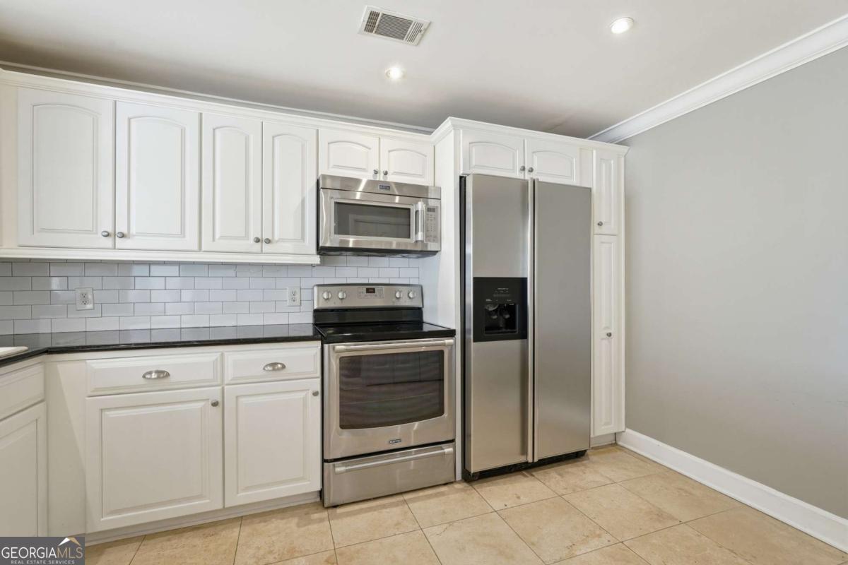 700 Wilmington Island Road, Unit 201 Savannah, GA 31410 - Photo 21 of 51 a kitchen with white cabinets stainless steel appliances and a sink