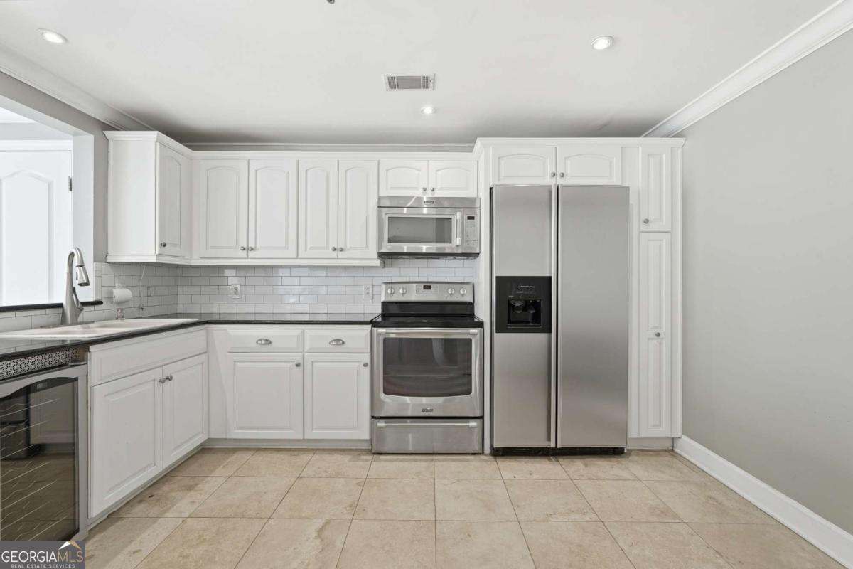700 Wilmington Island Road, Unit 201 Savannah, GA 31410 - Photo 22 of 51 a kitchen with a refrigerator and a sink
