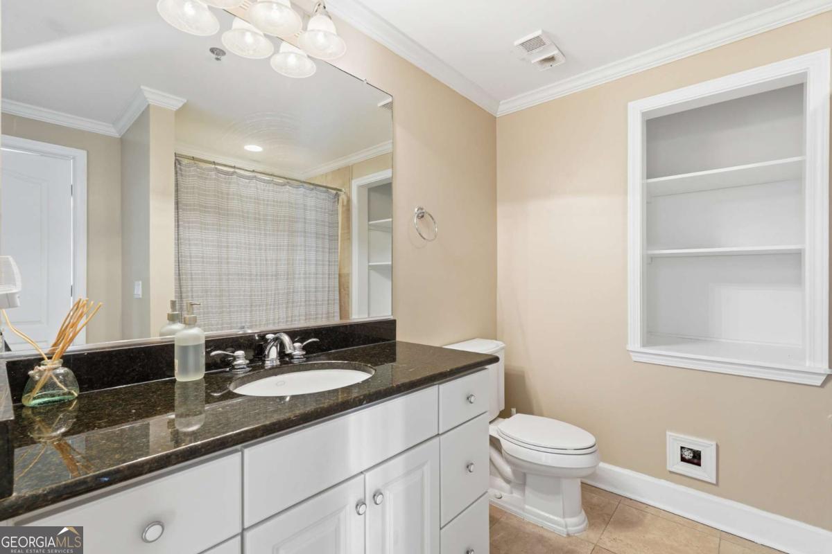 700 Wilmington Island Road, Unit 201 Savannah, GA 31410 - Photo 28 of 51 a bathroom with a sink a toilet a mirror and vanity