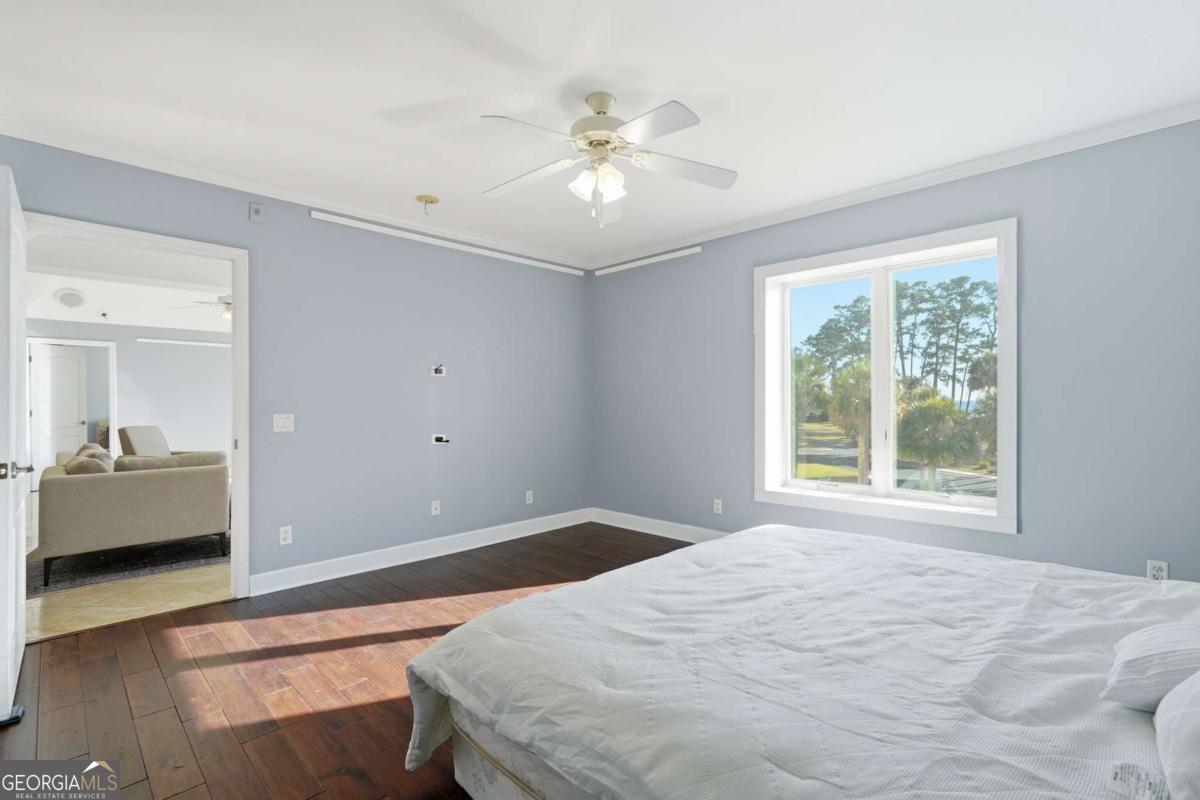 700 Wilmington Island Road, Unit 201 Savannah, GA 31410 - Photo 33 of 51 a bedroom with a large bed and a chandelier