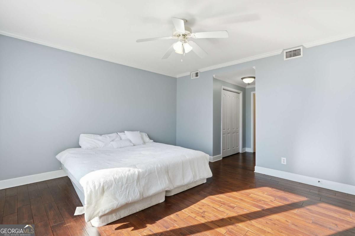 700 Wilmington Island Road, Unit 201 Savannah, GA 31410 - Photo 35 of 51 a bedroom with a bed and a ceiling fan