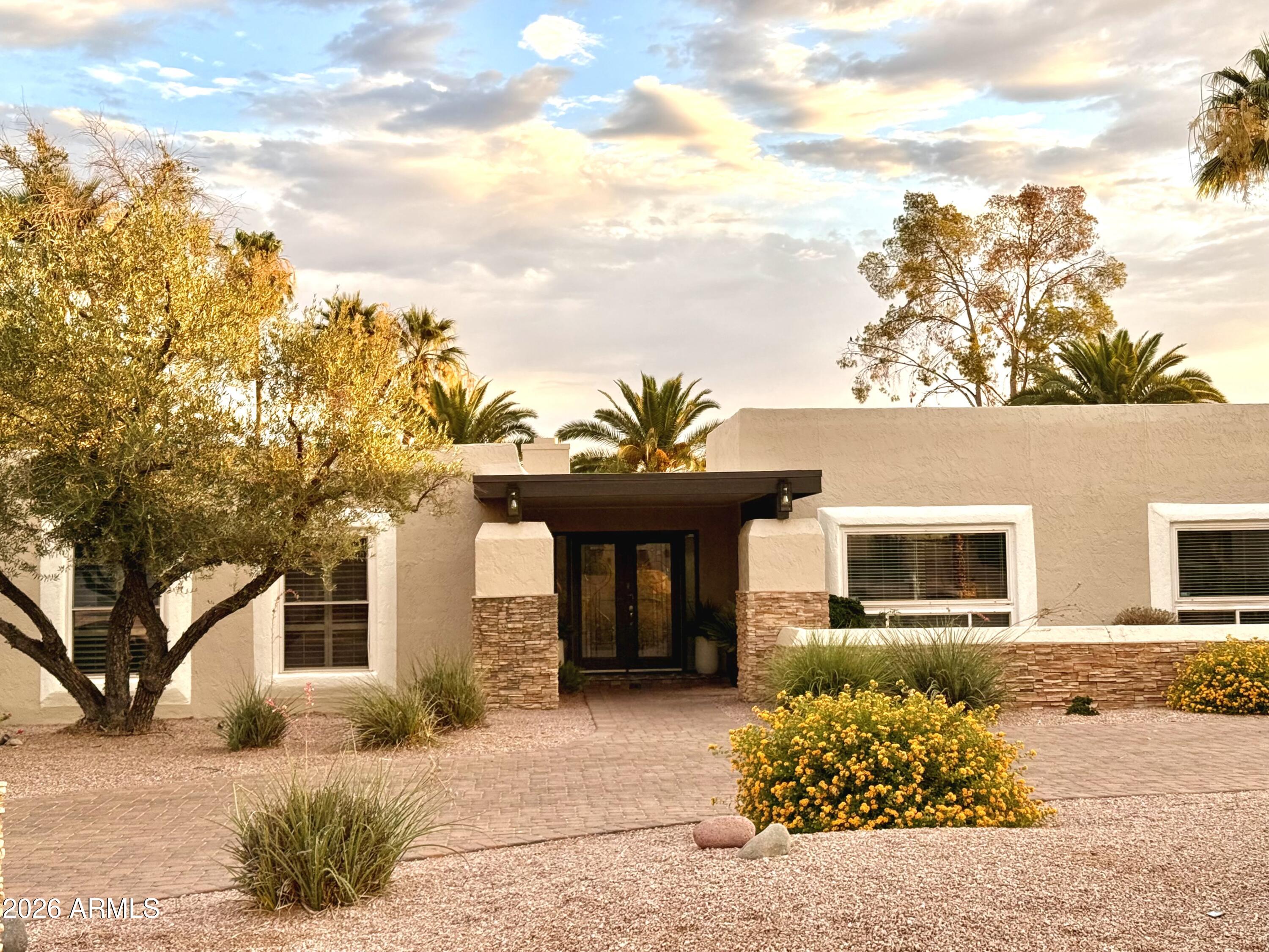 6932 East Presidio Road Scottsdale, AZ 85254 - Photo 28 of 30 a front view of a house with a yard and garage