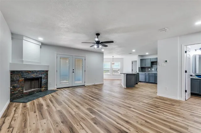 a view of empty room with wooden floor and fireplace