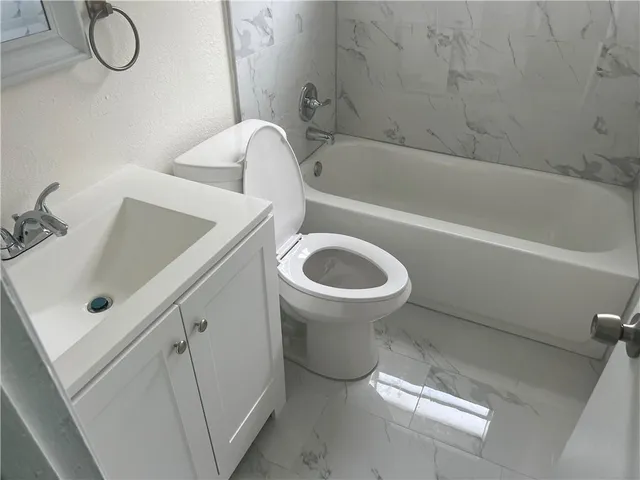 a kitchen with a sink dishwasher a refrigerator and a stove with wooden floor