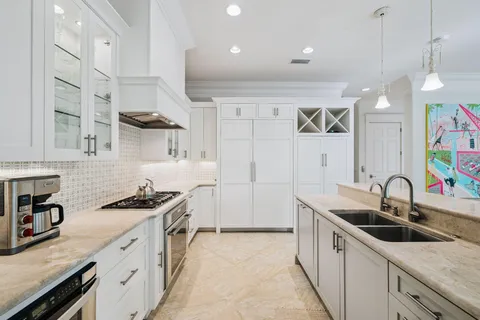 a kitchen with stainless steel appliances a sink stove and cabinets